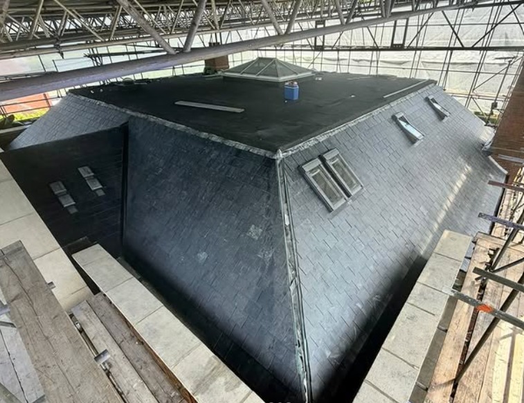 Large natural slate re-roof with roof windows under full scaffolding
