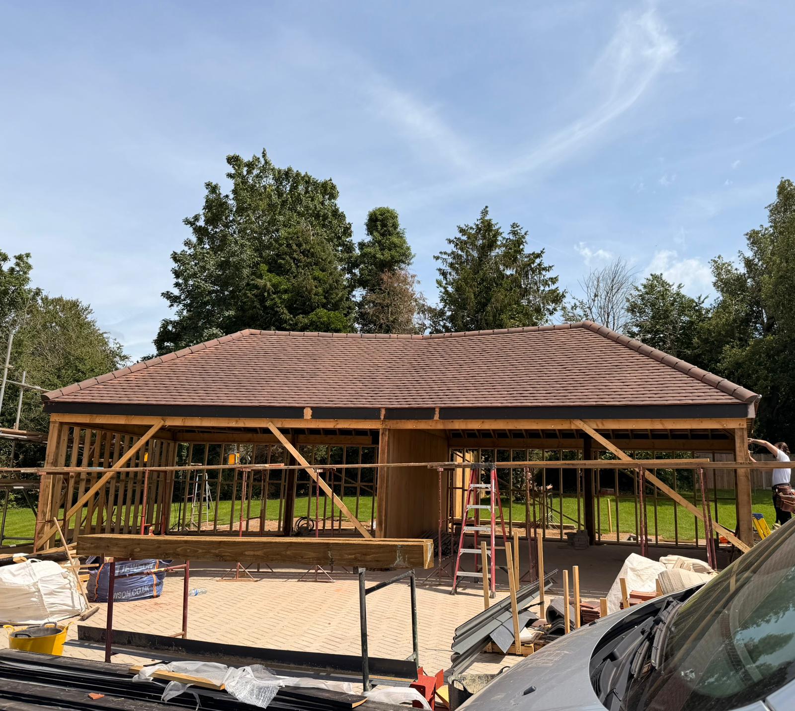 Completed clay tiled roof laid over a timber-framed building by Heritage Roof & Lead Co.
